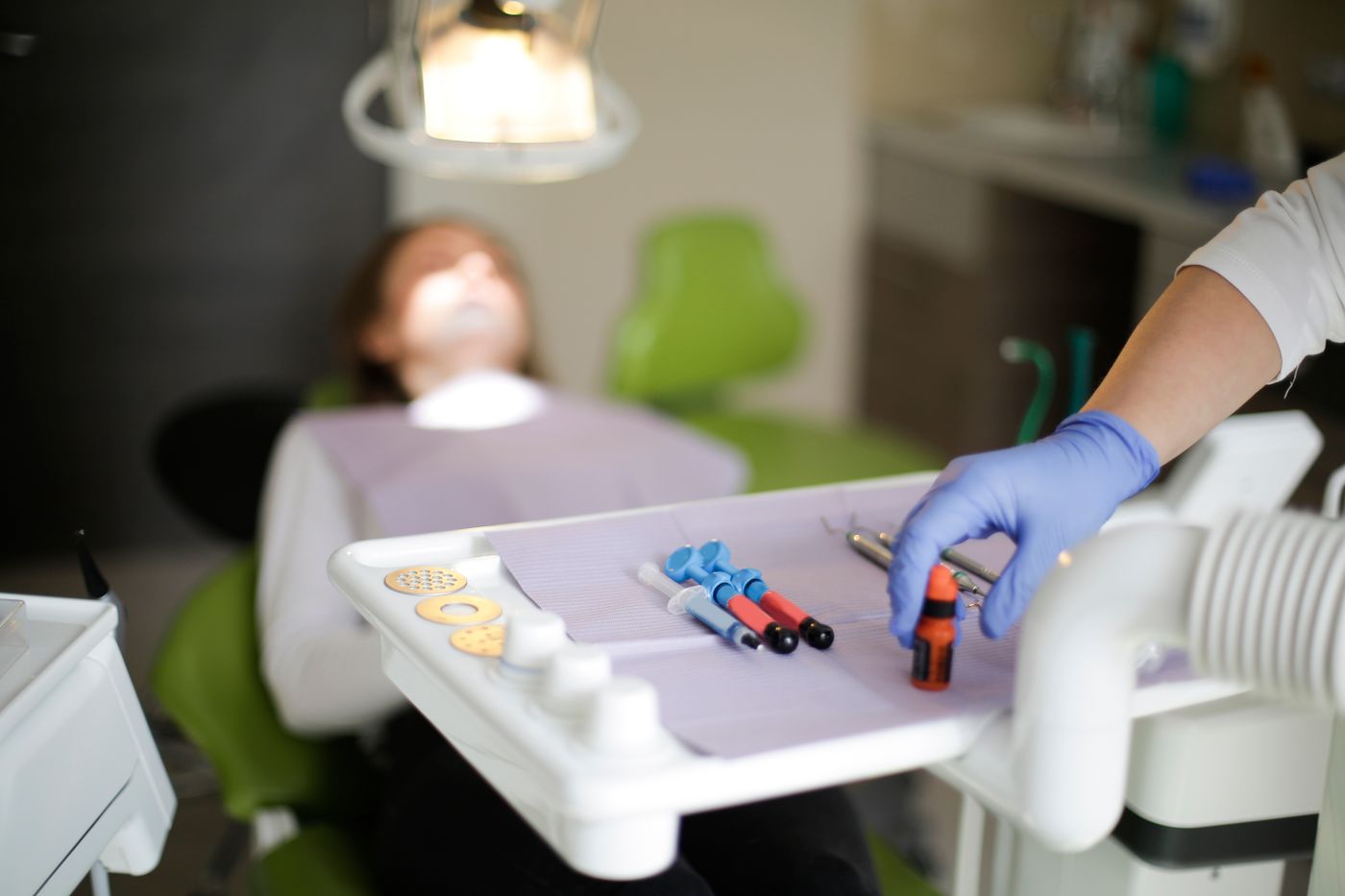 Gloved hand selecting composite resin compules from an instrument tray